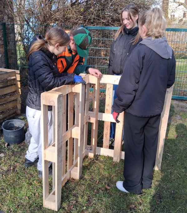 Schülerinnen bauen einen Komposter